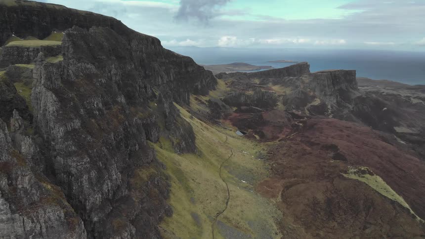A rocky cliff near the coast with the sky in the background