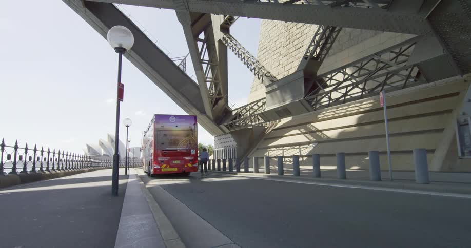 A roller skater holding onto the back of a bus to be pulled down the road