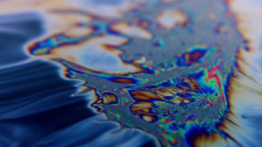 Thick fluid flows as it gives off psychedelic colors