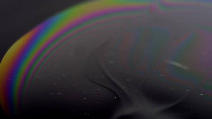 Abstract footage of colored dye moving in black liquid
