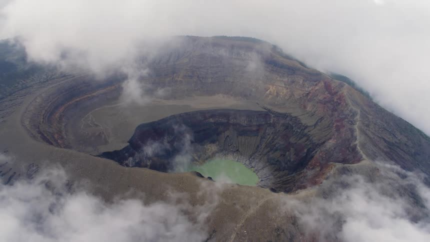 A rocky crater surrounded by clouds