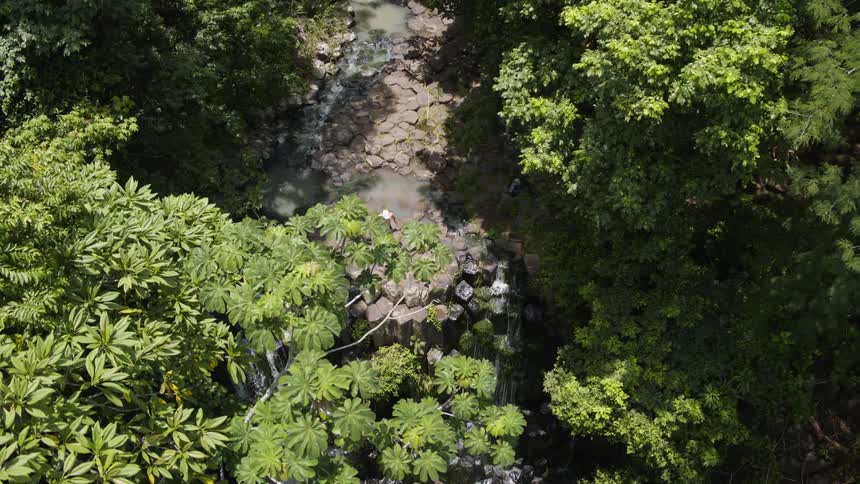A man walks to the edge of waterfall