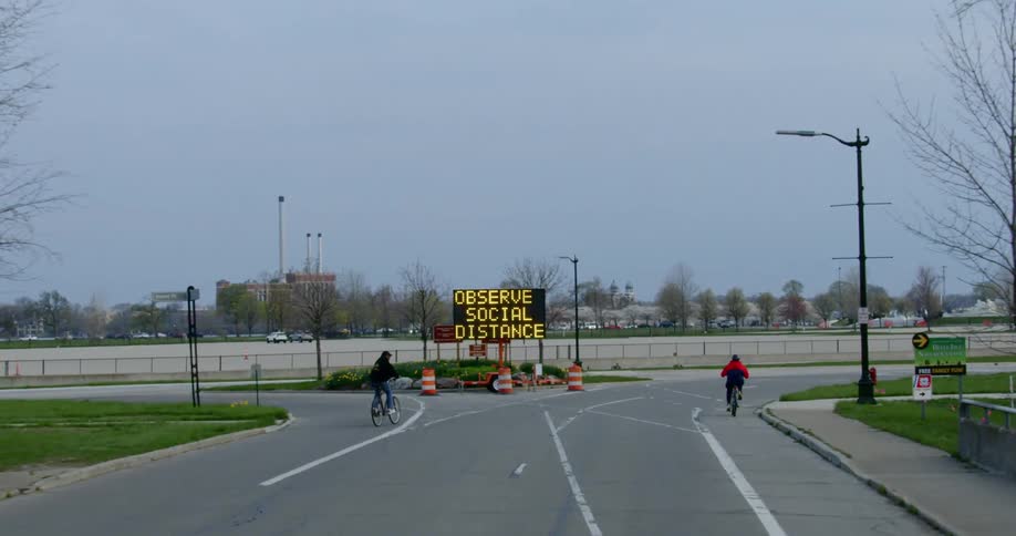 Two bicyclists ride down a deserted street
