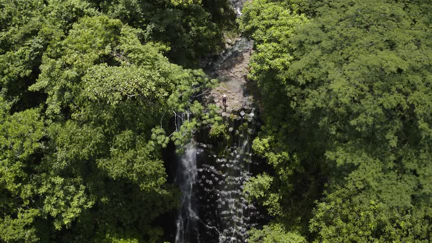 A waterfall courses over a cliff in El Salvador