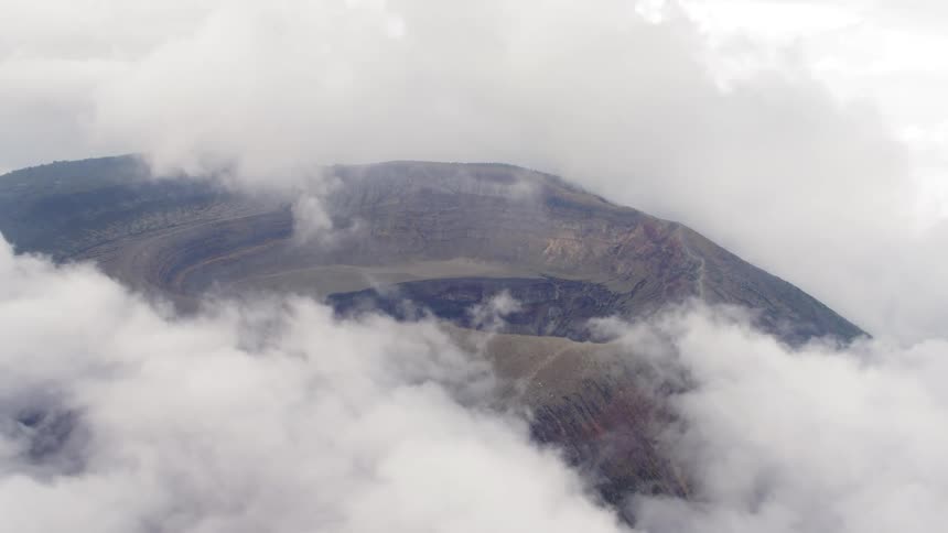 A rocky crater surrounded by clouds