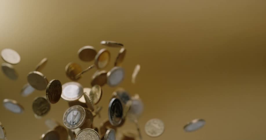 Coins being tossed up and falling down with a brown background