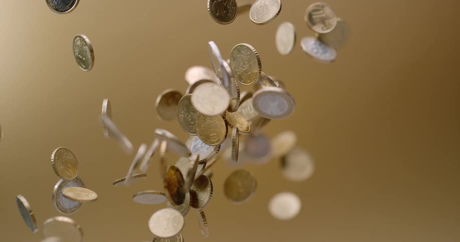 Coins tossing up and falling down with a brown background