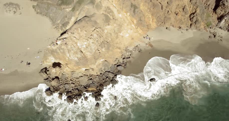 Aerial shot of waves hitting a beach