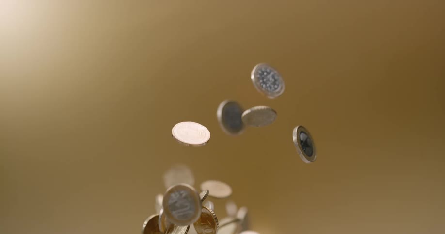 Coins being tossed up and falling down with a brown background