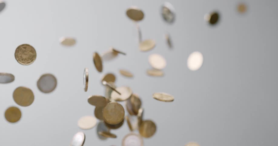 Coins being tossed up and falling down with a white background
