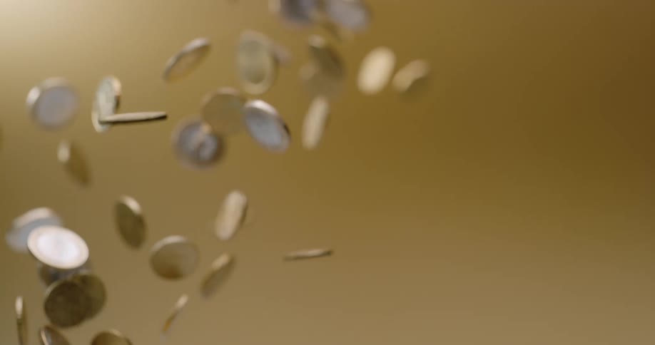 Several coins are tossed in the air from below and drop down