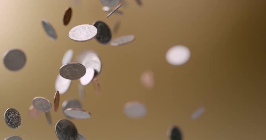 Coins being thrown up in the air and falling in slow motion
