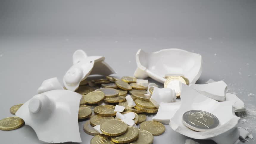 A broken piggy bank with money is displayed