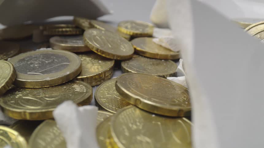 Coins sitting on a table with pieces of rock