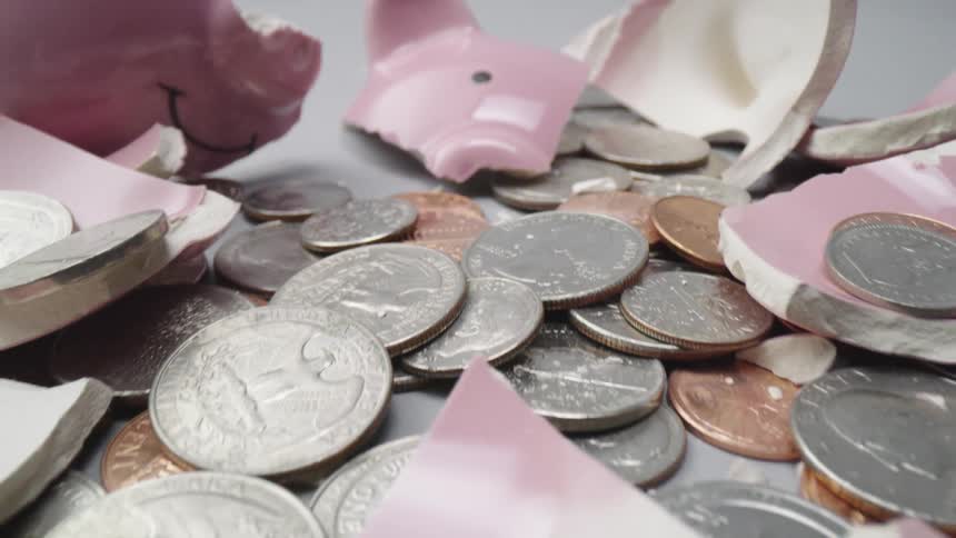A broken piggy bank and spilled coins