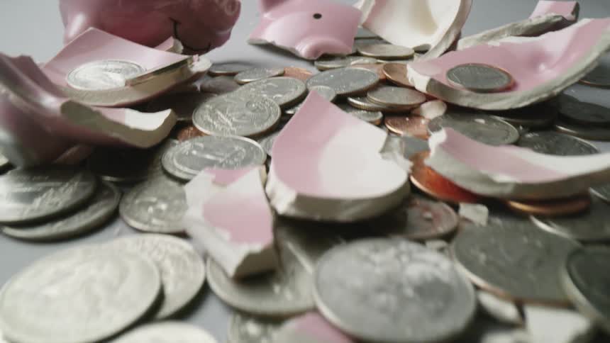 Hammer broken piggy bank box and scattered coins