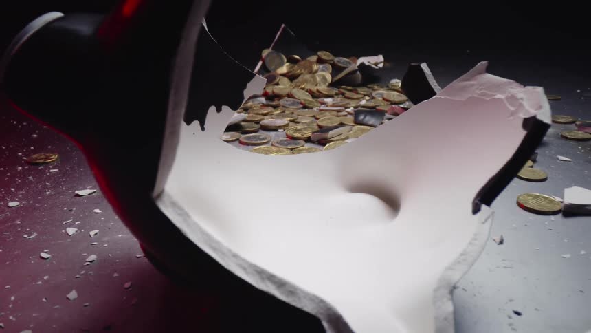 Hammer broken piggy bank box and scattered coins