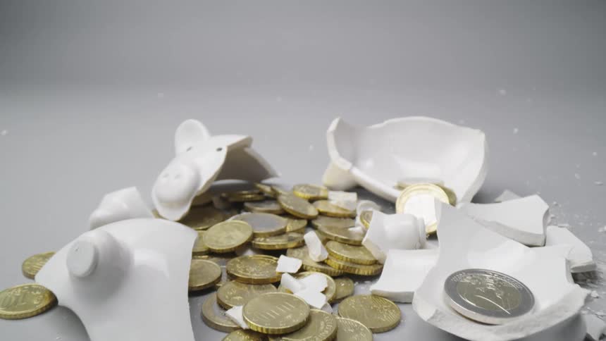 Shattered white piggy bank and tokens laying in a pile