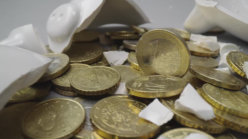 Coins sit on a table with a shattered salt shaker