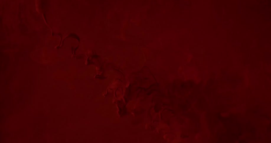 Abstract footage of liquid dye mixing in with another liquid