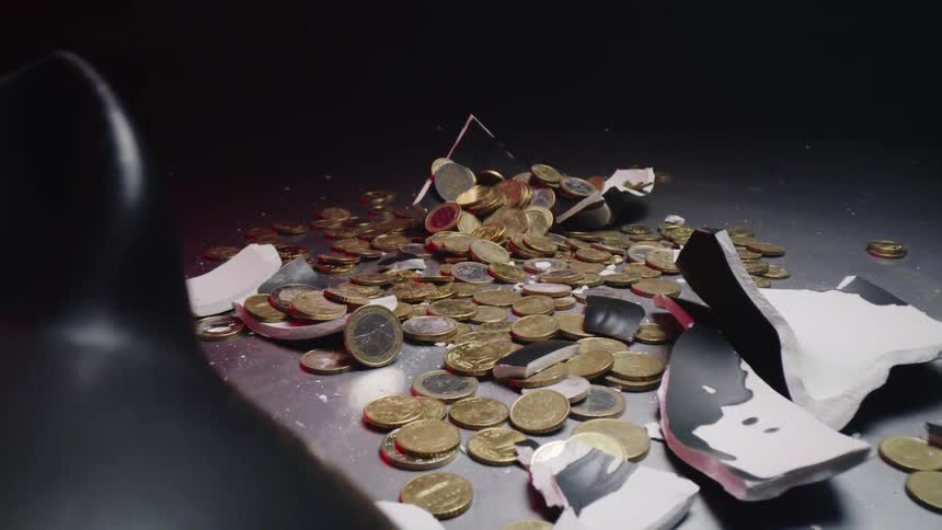 A piggy bank is broken and currency is displayed