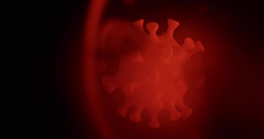 A red virus shape sits suspended in some type of fluid