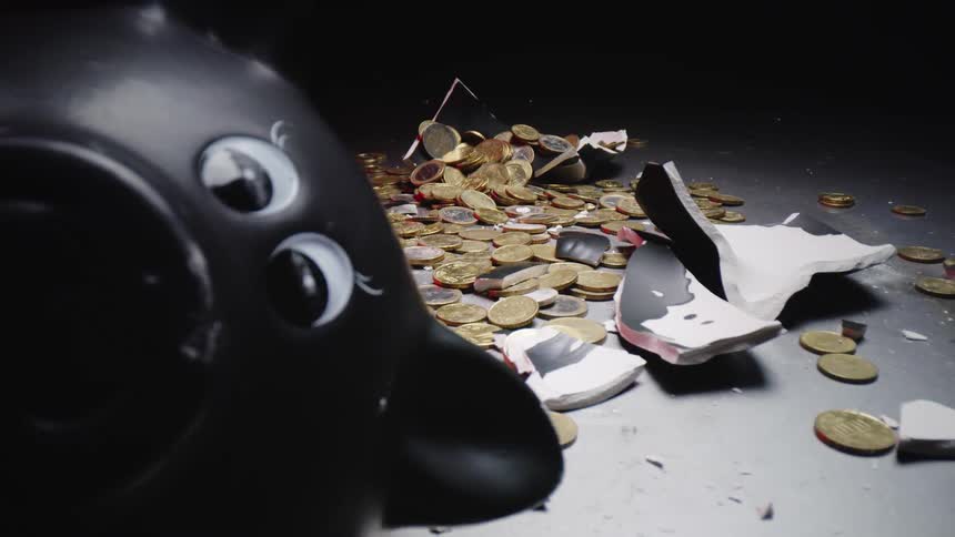 A broken piggy bank is displayed with coins