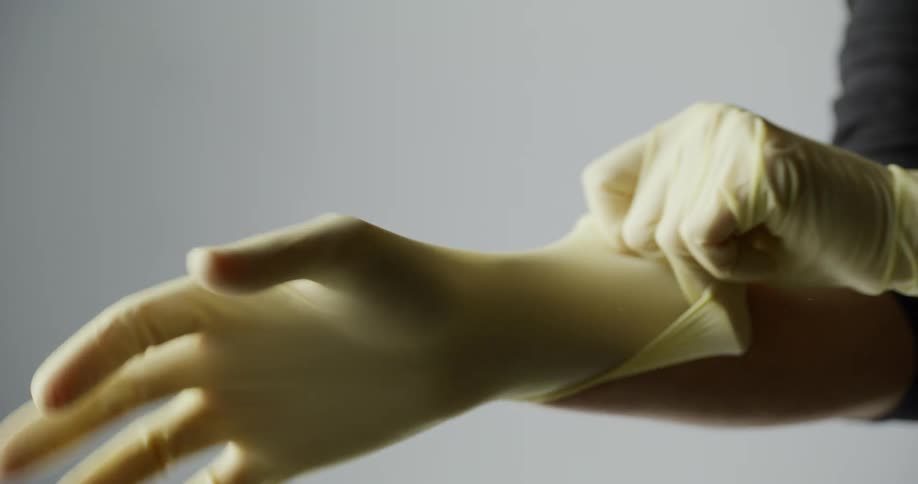 A person putting on protective gloves