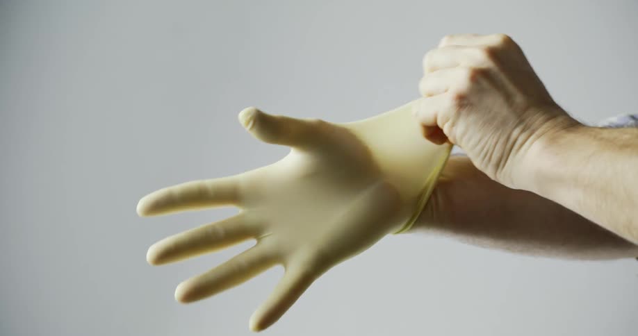 A man puts rubber gloves on his hands