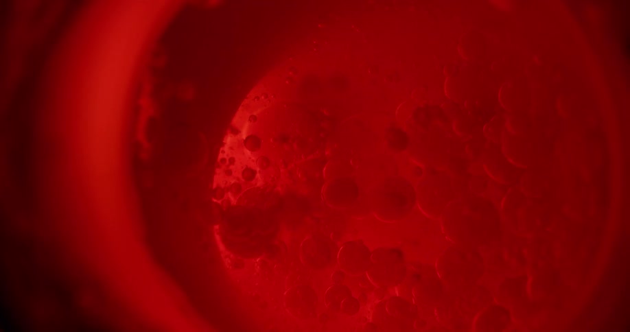 Bubbles floating on clear red liquid
