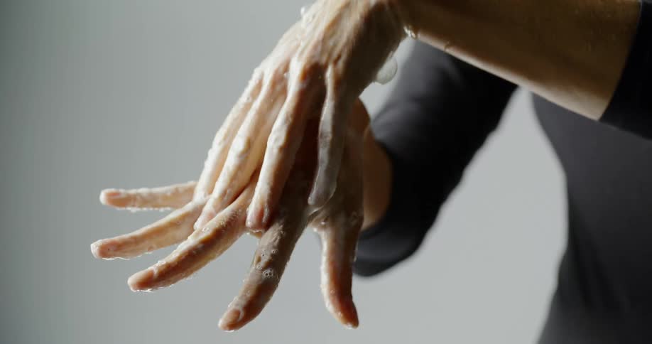 A person thoroughly soaping up their hands