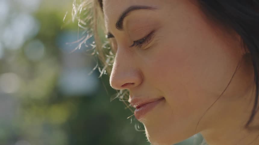 A woman smiling as the wind gently rustles her hair