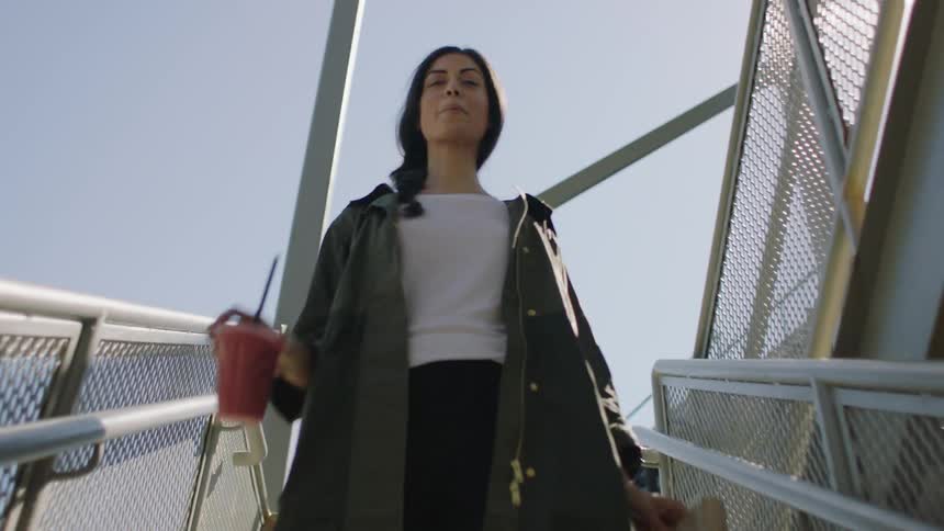 A woman walking down stairs with a drink
