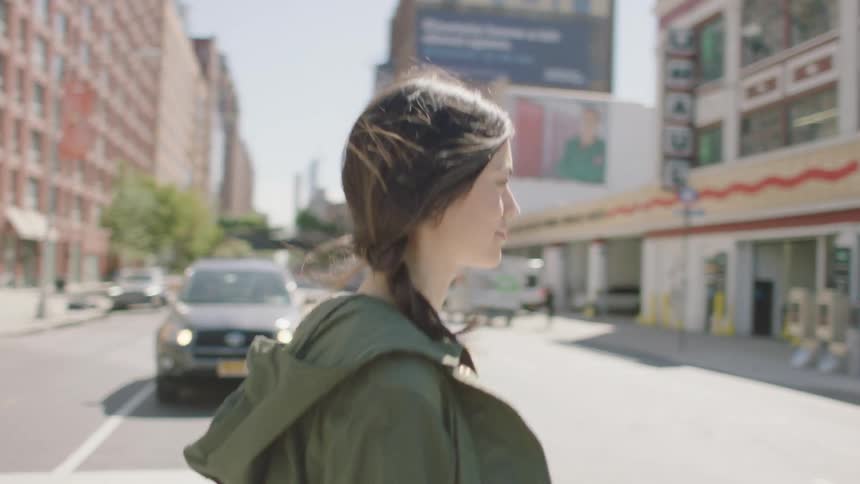 Traffic stops and woman crosses the pedestrian crossing in the city