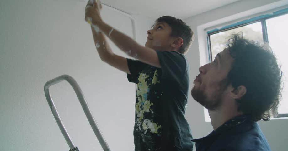 A father shows his son how to paint