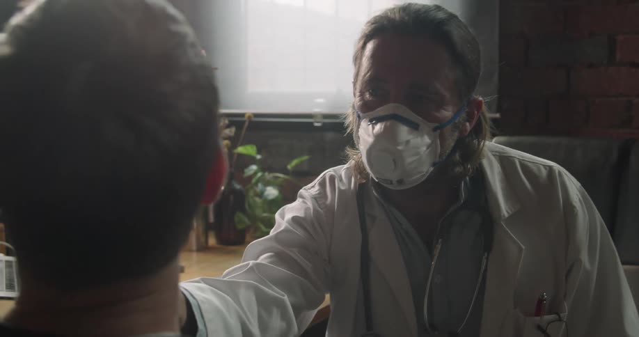 A doctor examines a male patient in his office