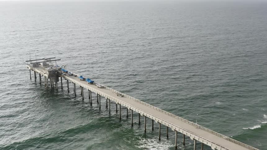 Boats line a pier on a coast
