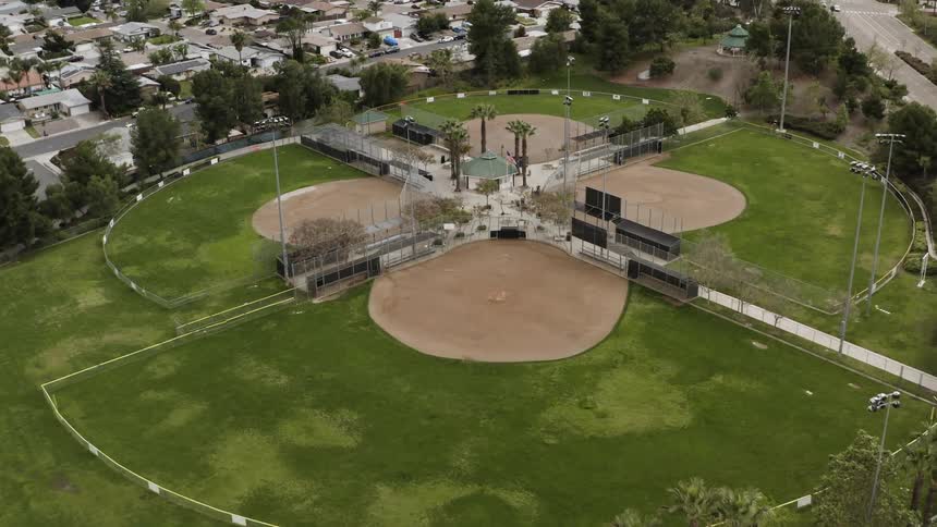 A set of baseball fields sit next to a neighborhood