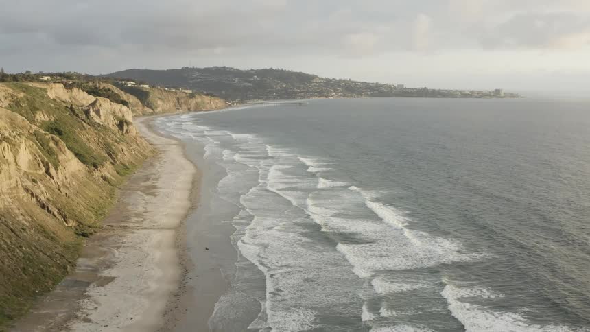 Aerial view of ocean waves crashing against the secluded shore