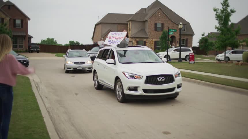 Cars drive through a neighborhood to wish a teenage girl happy birthday