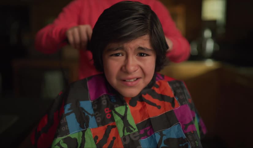 A hispanic boy makes a fearful face as hes about to get his hair cut