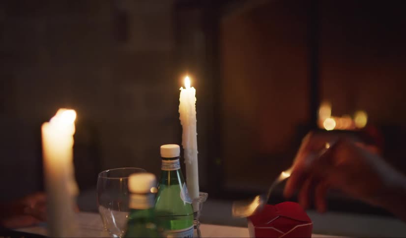 Close up of a Chinese takeout dinner by candle light.