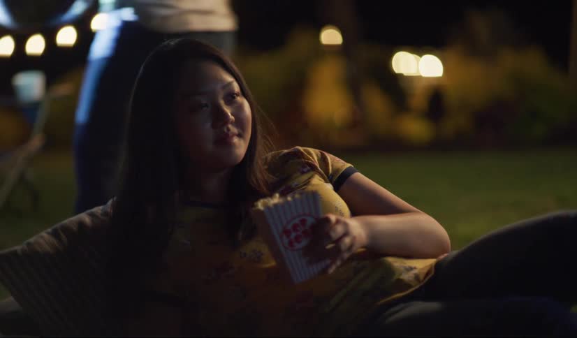 A woman lays down in the yard with popcorn
