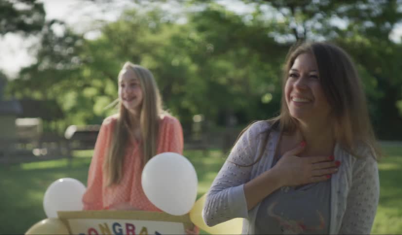 Two women clap and cheer for someone