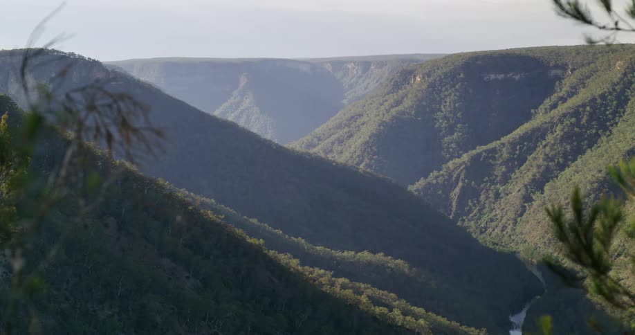 Sun casts parts of valley and mountains into shadows while lighting other parts