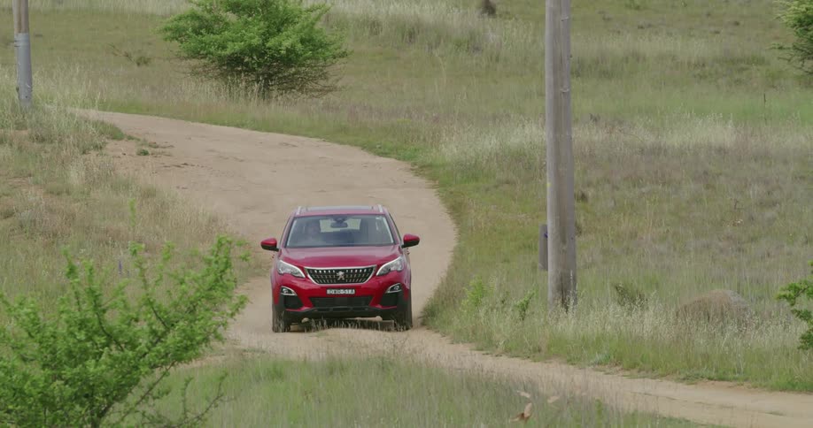 A man drives a vehicle down a dirt country road or driveway