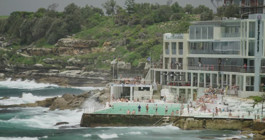 Several people enjoy resort built right on shore near ocean