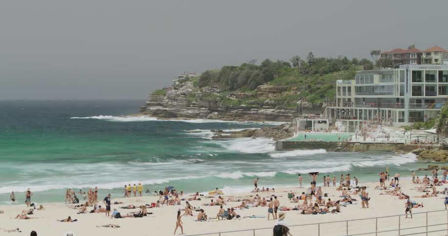 Beachgoers relax on the white sands of a beach at day