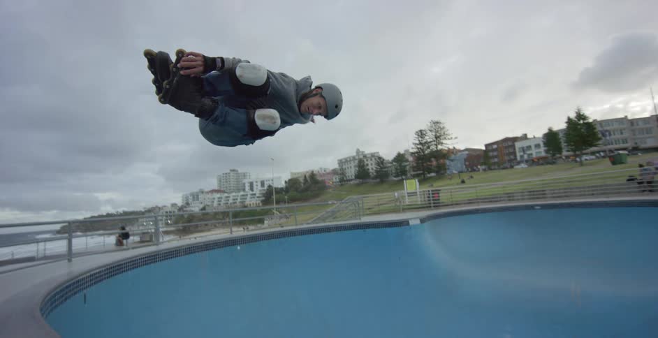 A person with inline skates doing tricks in a skate park