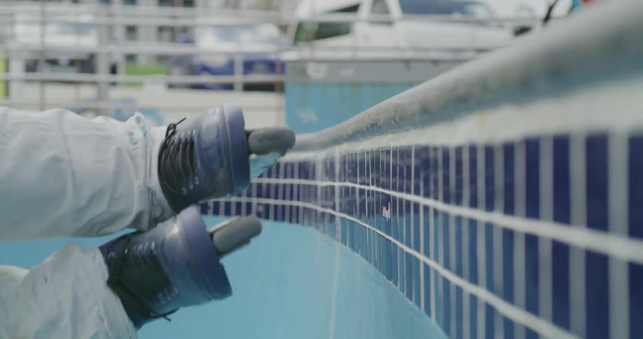 A person rollerblades on the side of an empty pool